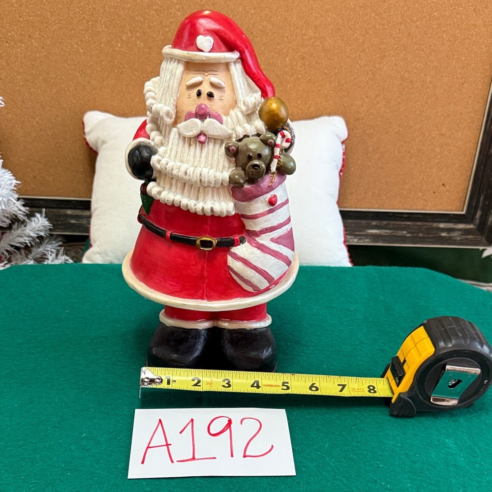 Festive Santa Claus Figurine holding a toy filled Stocking